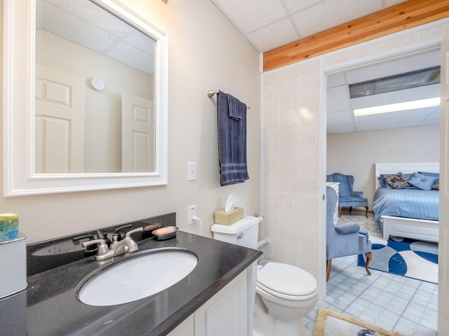 bathroom featuring a paneled ceiling, vanity, and toilet