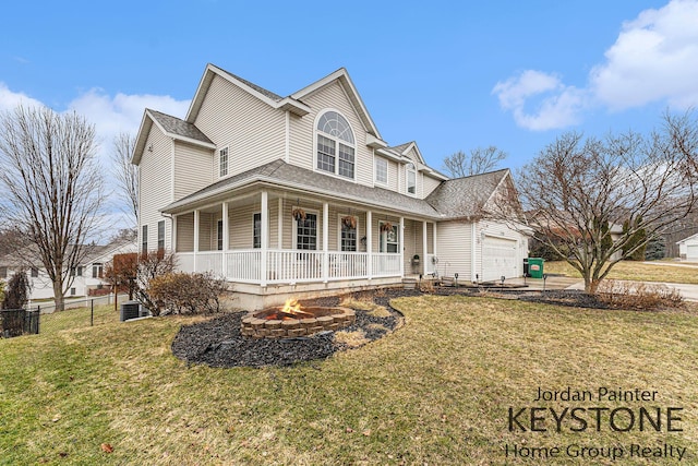 view of front of property featuring a porch, an outdoor fire pit, a garage, and a front yard