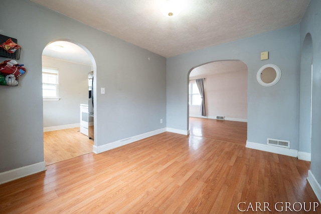 spare room featuring a textured ceiling and light wood-type flooring