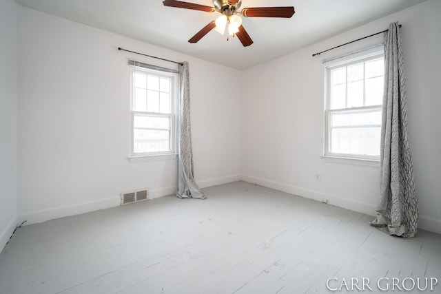 unfurnished room with ceiling fan and plenty of natural light