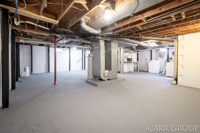 basement featuring heating unit and washer and clothes dryer