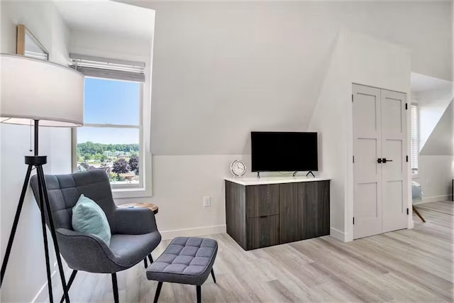 sitting room featuring lofted ceiling and light wood-type flooring