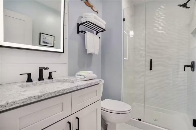 bathroom with vanity, toilet, and a shower with shower door