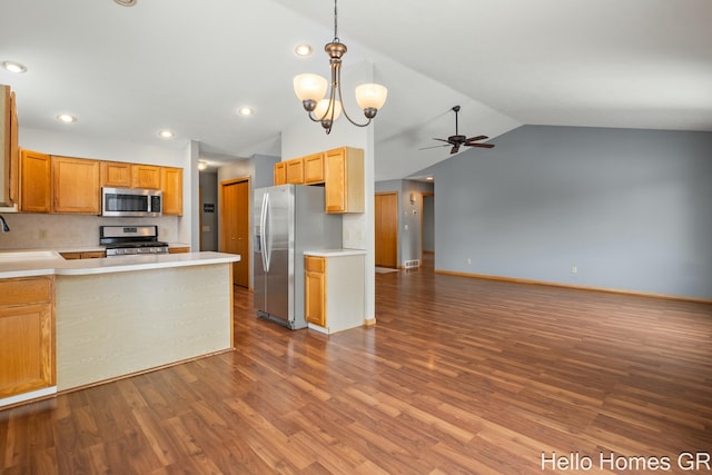 kitchen with appliances with stainless steel finishes, light hardwood / wood-style flooring, ceiling fan with notable chandelier, and decorative light fixtures