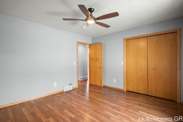 unfurnished bedroom with light hardwood / wood-style flooring, a closet, and ceiling fan