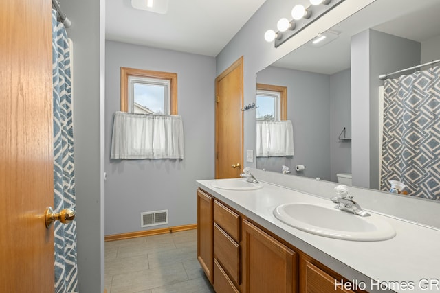 bathroom featuring a healthy amount of sunlight, toilet, and vanity