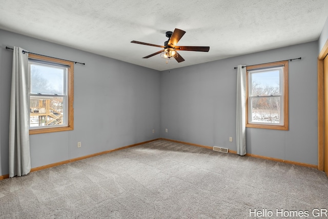 unfurnished room with ceiling fan, carpet, and a textured ceiling