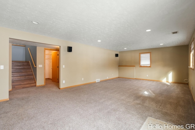 unfurnished room featuring light carpet and a textured ceiling