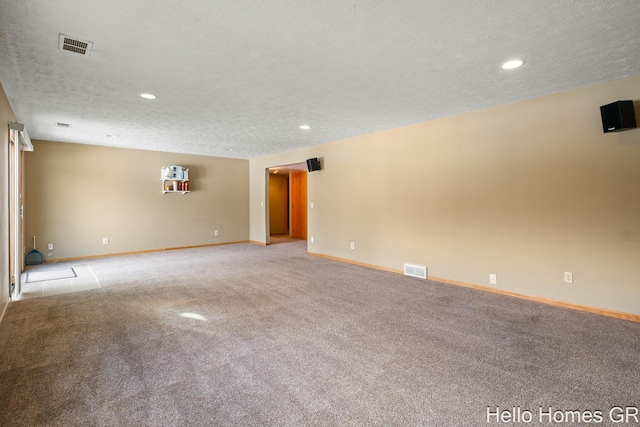 unfurnished room with light colored carpet and a textured ceiling