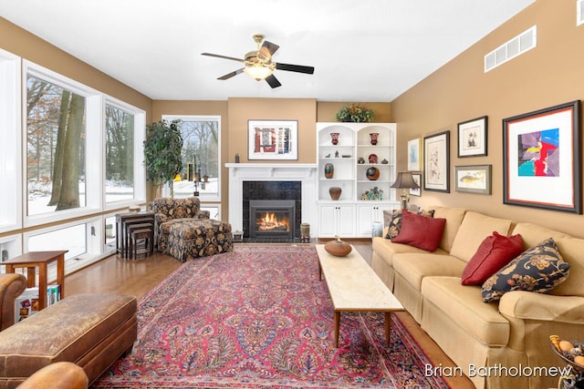 living room with ceiling fan, a fireplace, and hardwood / wood-style floors