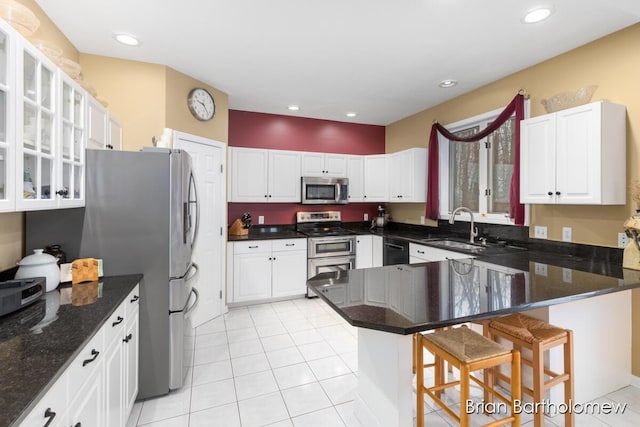 kitchen with sink, white cabinetry, appliances with stainless steel finishes, a kitchen breakfast bar, and kitchen peninsula