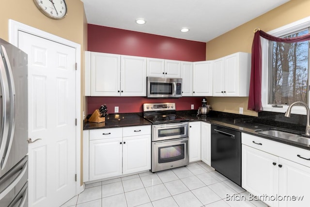 kitchen featuring light tile patterned flooring, stainless steel appliances, sink, and white cabinets