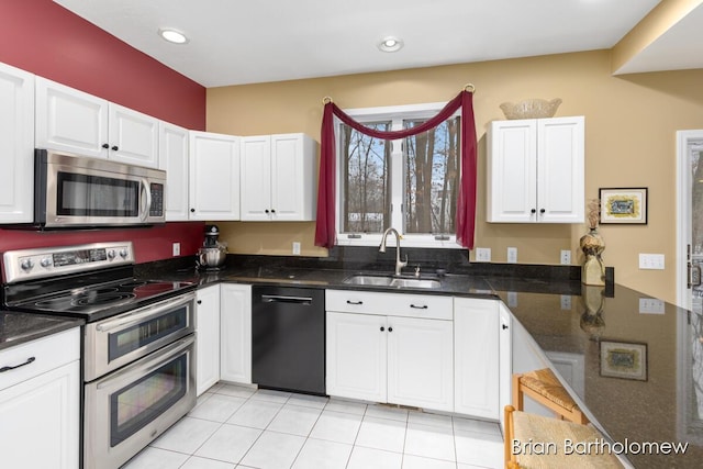 kitchen with white cabinetry, sink, stainless steel appliances, and dark stone counters