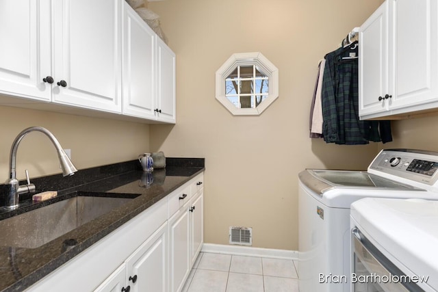 laundry room featuring cabinets, sink, light tile patterned floors, and washing machine and clothes dryer