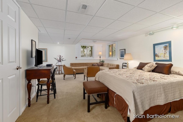 bedroom with light colored carpet and a drop ceiling