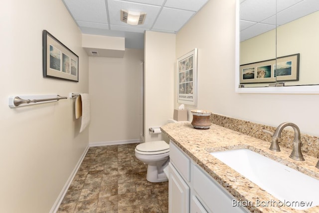 bathroom featuring vanity, a paneled ceiling, and toilet