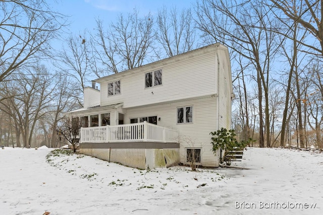 snow covered house featuring a deck