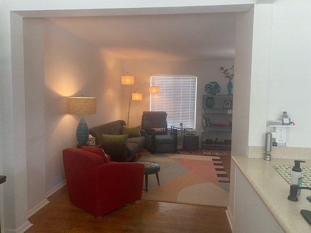 living area with baseboards and wood finished floors