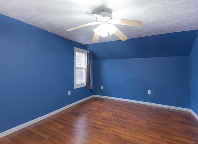 additional living space with lofted ceiling, a textured ceiling, dark hardwood / wood-style floors, and ceiling fan