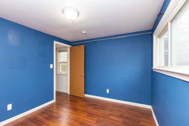 unfurnished room with dark wood-type flooring