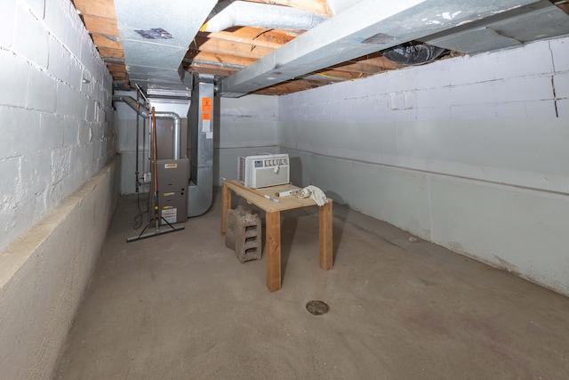 basement featuring heating unit and a wall mounted AC