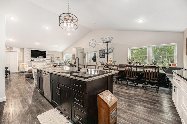 2678 Richmond St NW, Grand Rapids, MI 49504 - kitchen with dark wood-style flooring, light stone countertops, a center island with sink, open floor plan, and pendant lighting