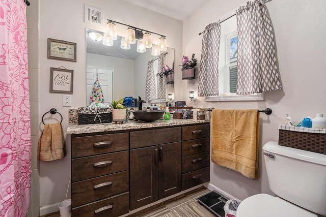 2678 Richmond St NW, Grand Rapids, MI 49504 - bathroom featuring toilet, baseboards, visible vents, and vanity