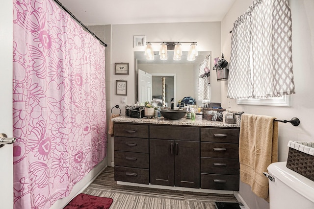 2678 Richmond St NW, Grand Rapids, MI 49504 - full bath featuring wood finished floors, vanity, baseboards, toilet, and a notable chandelier