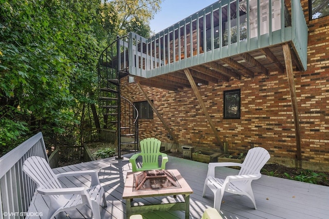 wooden deck featuring stairway and a fire pit