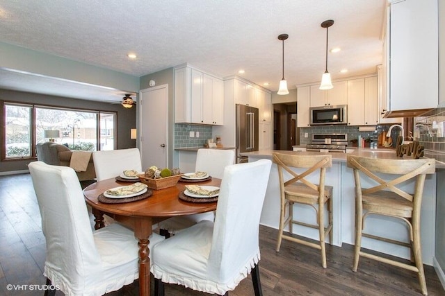 dining space featuring ceiling fan, dark wood finished floors, a textured ceiling, and recessed lighting