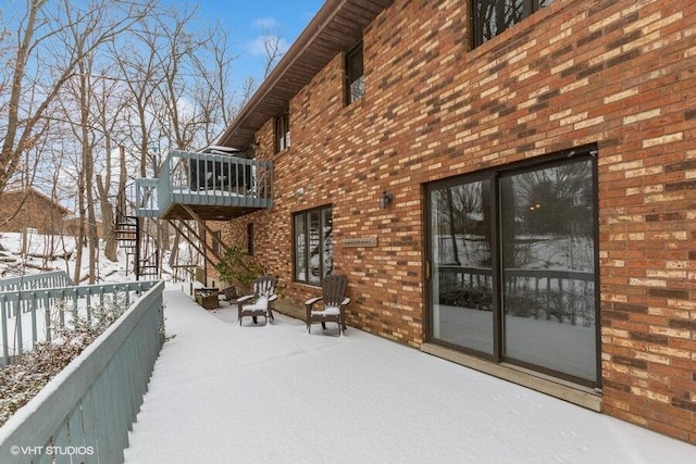 exterior space featuring a deck, brick siding, and stairway