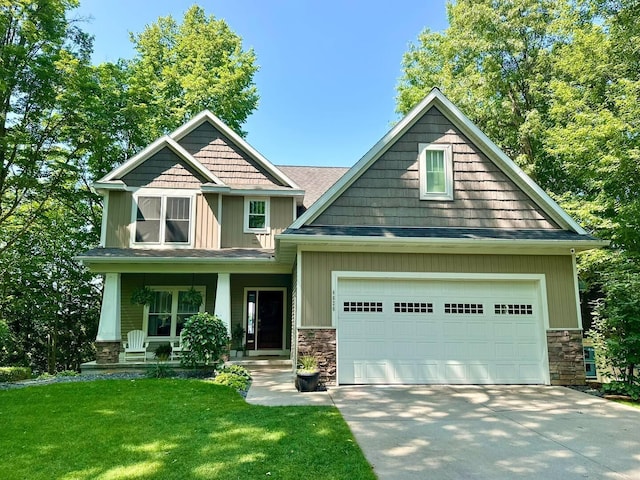 craftsman inspired home with a porch, a garage, and a front lawn