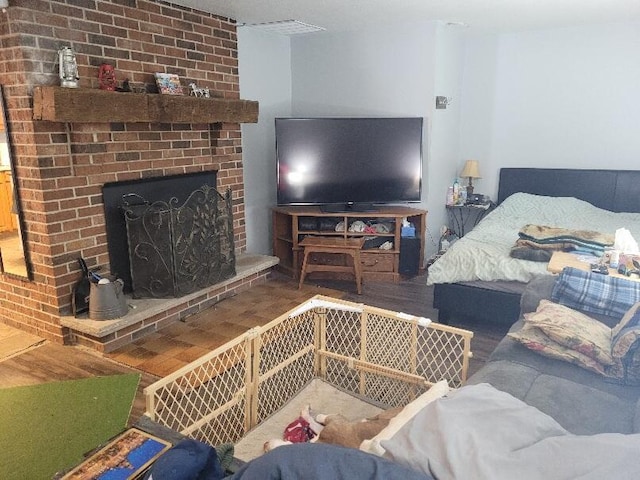 bedroom with a fireplace and wood-type flooring