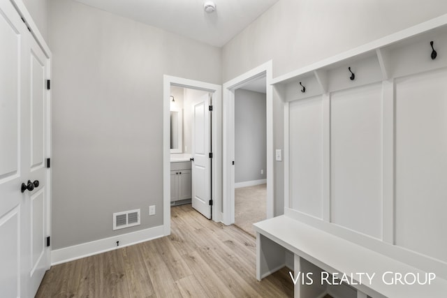 mudroom featuring baseboards, visible vents, and light wood-type flooring