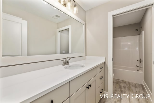 full bath with vanity, wood finished floors, visible vents, toilet, and shower / bath combination