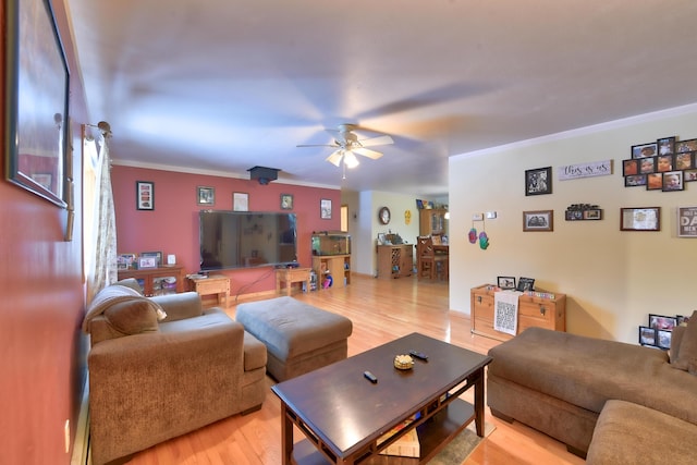 living room with hardwood / wood-style flooring, ornamental molding, and ceiling fan