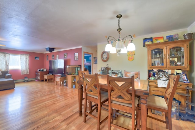 dining room featuring light hardwood / wood-style flooring, a baseboard radiator, and a chandelier