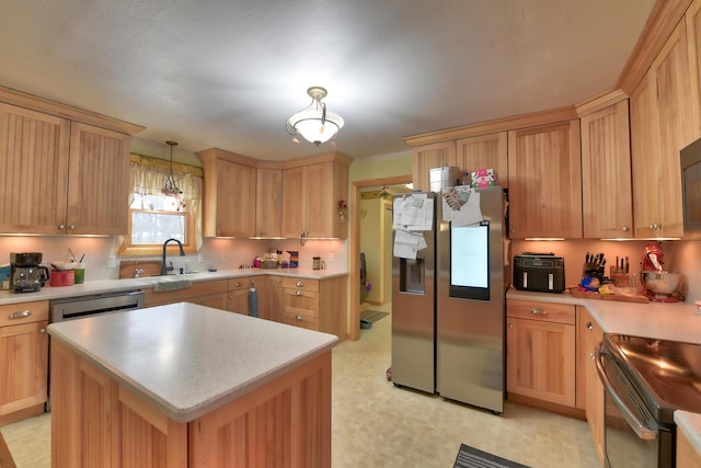 kitchen with sink, decorative light fixtures, stainless steel appliances, and a center island