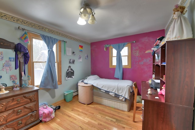 bedroom with baseboard heating and light wood-type flooring