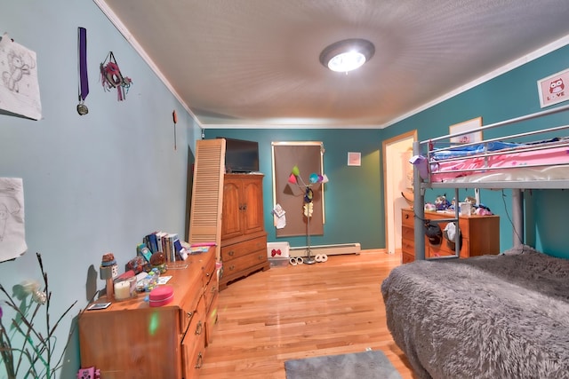 bedroom with baseboard heating, ornamental molding, and hardwood / wood-style floors