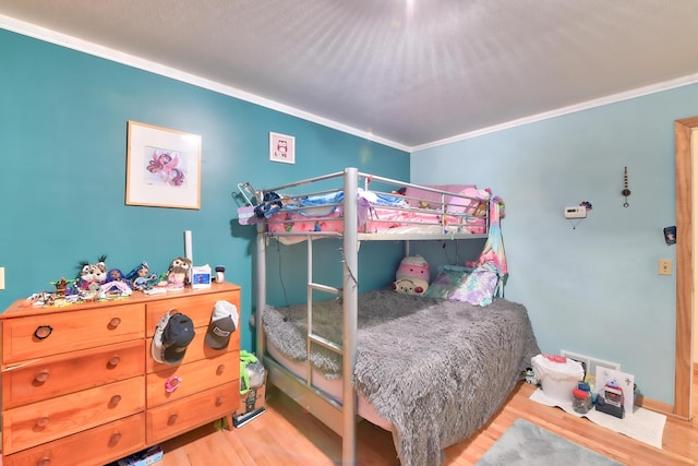 bedroom with crown molding and light wood-type flooring