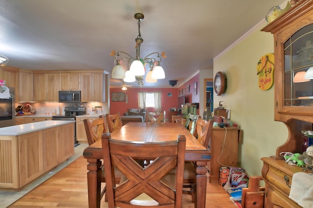 dining room featuring ornamental molding, a notable chandelier, and light hardwood / wood-style flooring