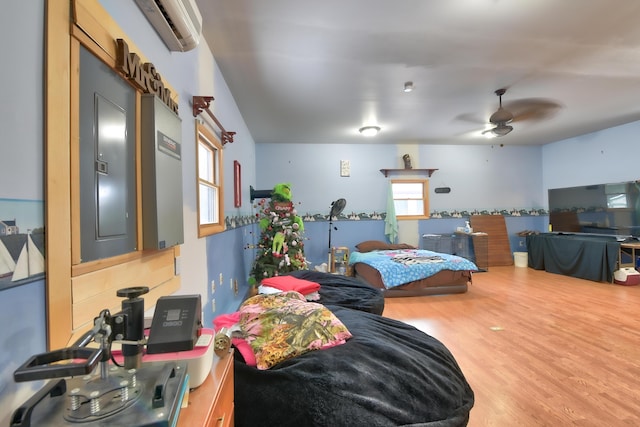 living room featuring an AC wall unit, hardwood / wood-style floors, and ceiling fan