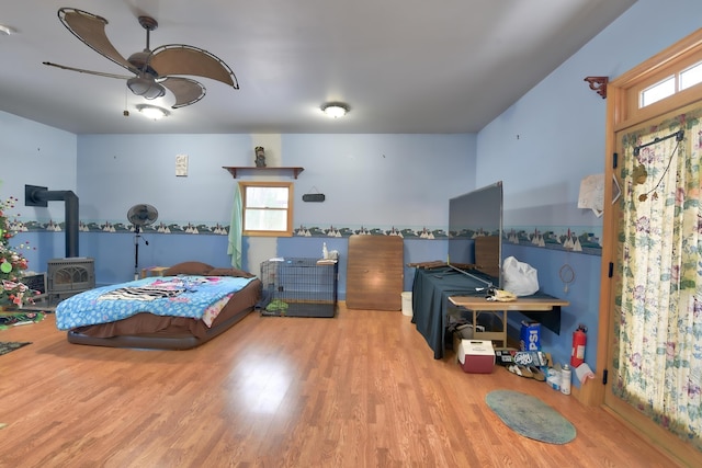 bedroom with wood-type flooring and a wood stove