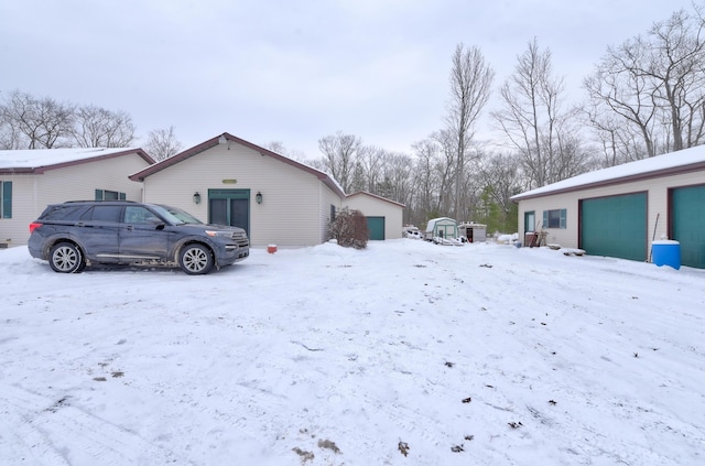 yard covered in snow featuring an outbuilding and a garage