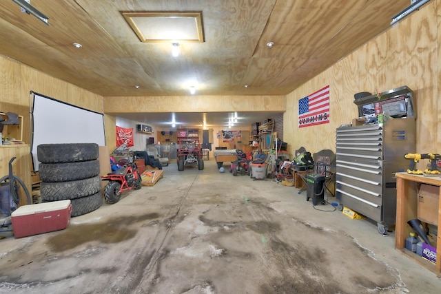 garage featuring wooden walls, wood ceiling, and a workshop area