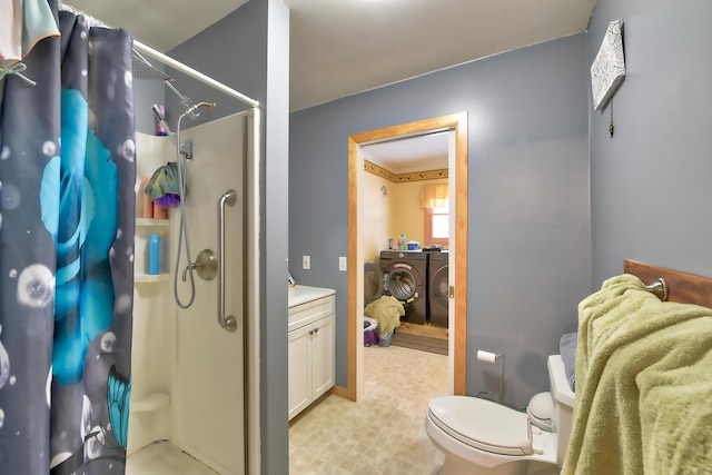 bathroom featuring washing machine and clothes dryer, vanity, toilet, and curtained shower