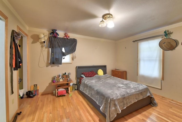 bedroom with wood-type flooring and ornamental molding