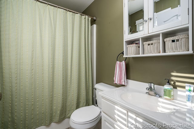 bathroom featuring vanity, walk in shower, and toilet