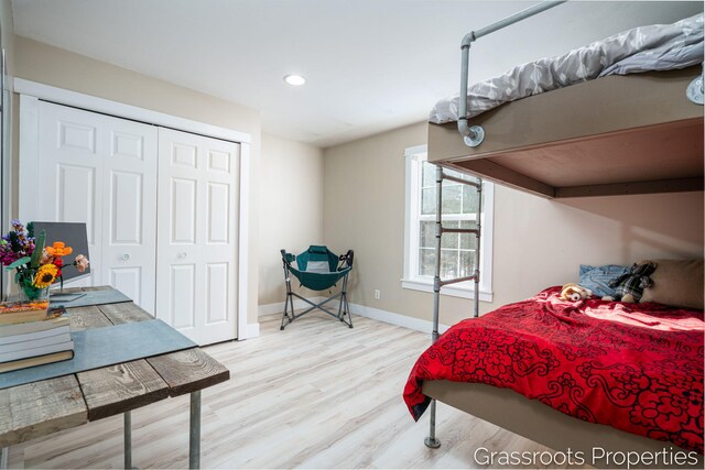 bedroom with light hardwood / wood-style floors and a closet